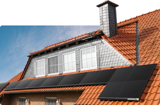 Rotes Ziegeldach mit Gaube und schwarzen Solarmodulen