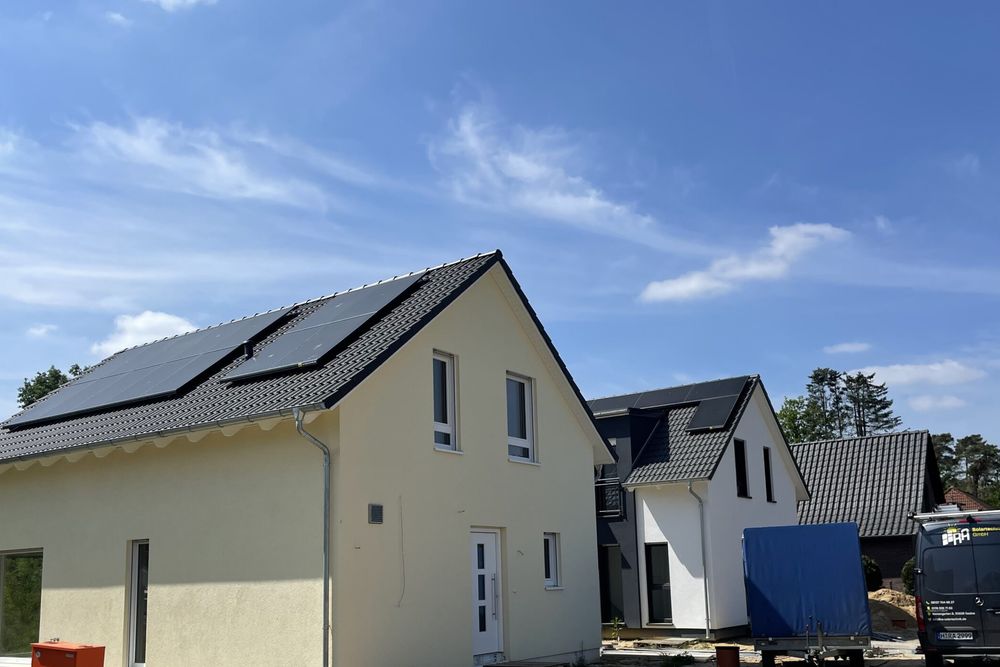 Neubau mit Photovoltaikanlage auf dem Satteldach unter blauem Himmel