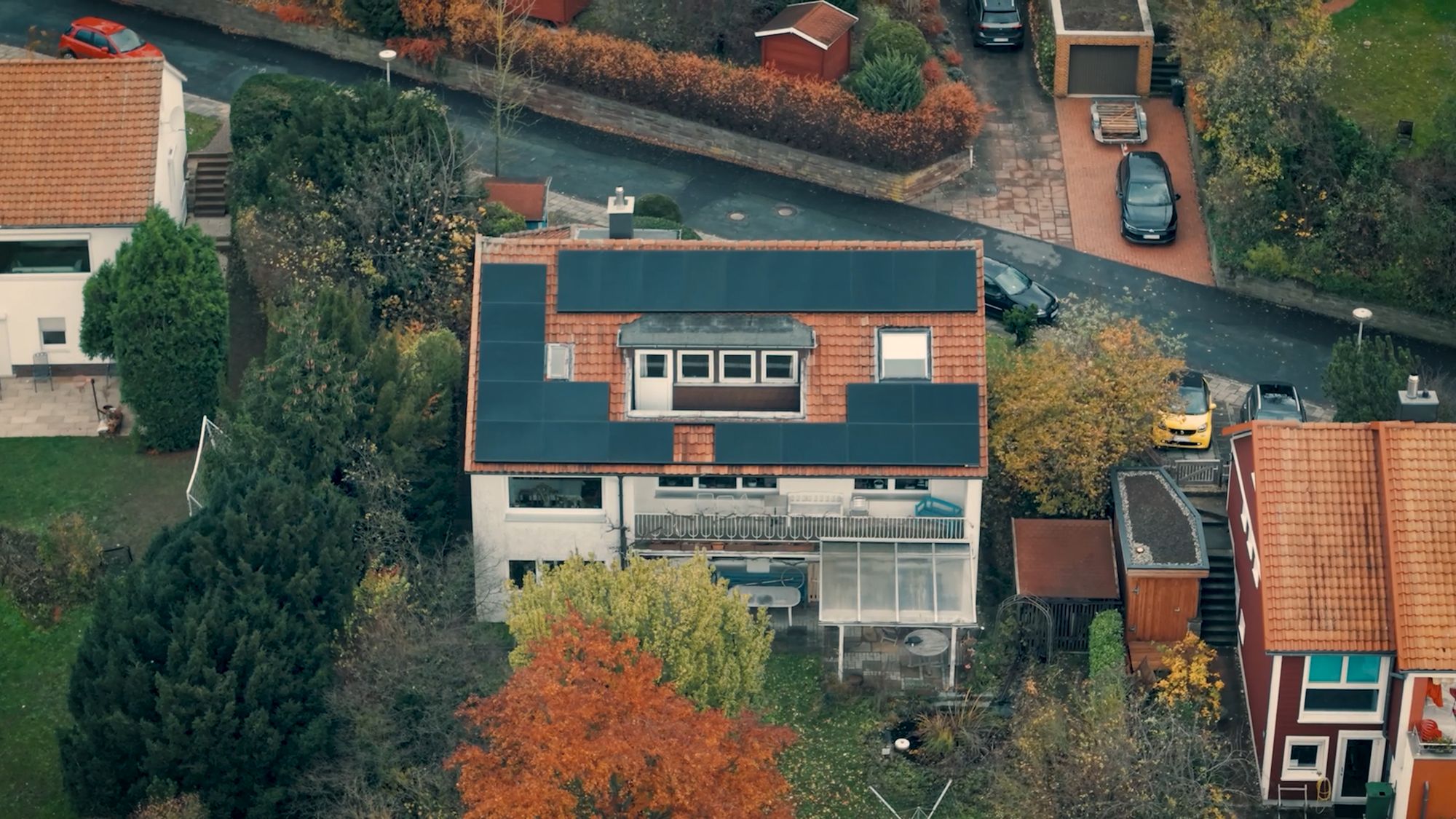 Photovoltaikanlage auf einem roten Ziegeldach mit Gaube (Drohnenaufnahme)