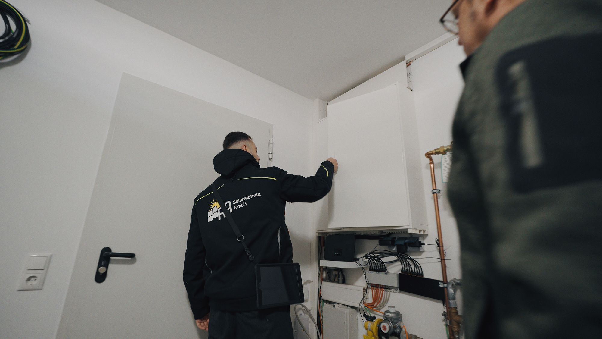 Mitarbeiter von RA Solartechnik arbeitet an der Haustechnik im Technikraum eines Kunden