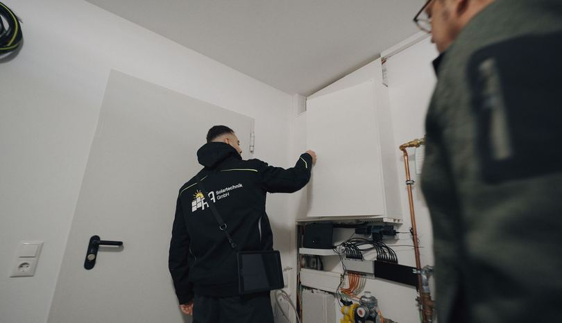 Mitarbeiter von RA Solartechnik arbeitet an der Haustechnik im Technikraum eines Kunden