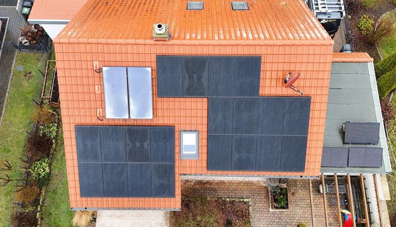 Photovoltaikanlage und Solarthermie auf einem orangen Ziegeldach in Bad Nenndorf (Drohnenaufnahme)