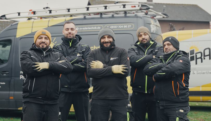 Das Team von RA Solartechnik steht mit verschränkten Armen vor dem Firmentransporter