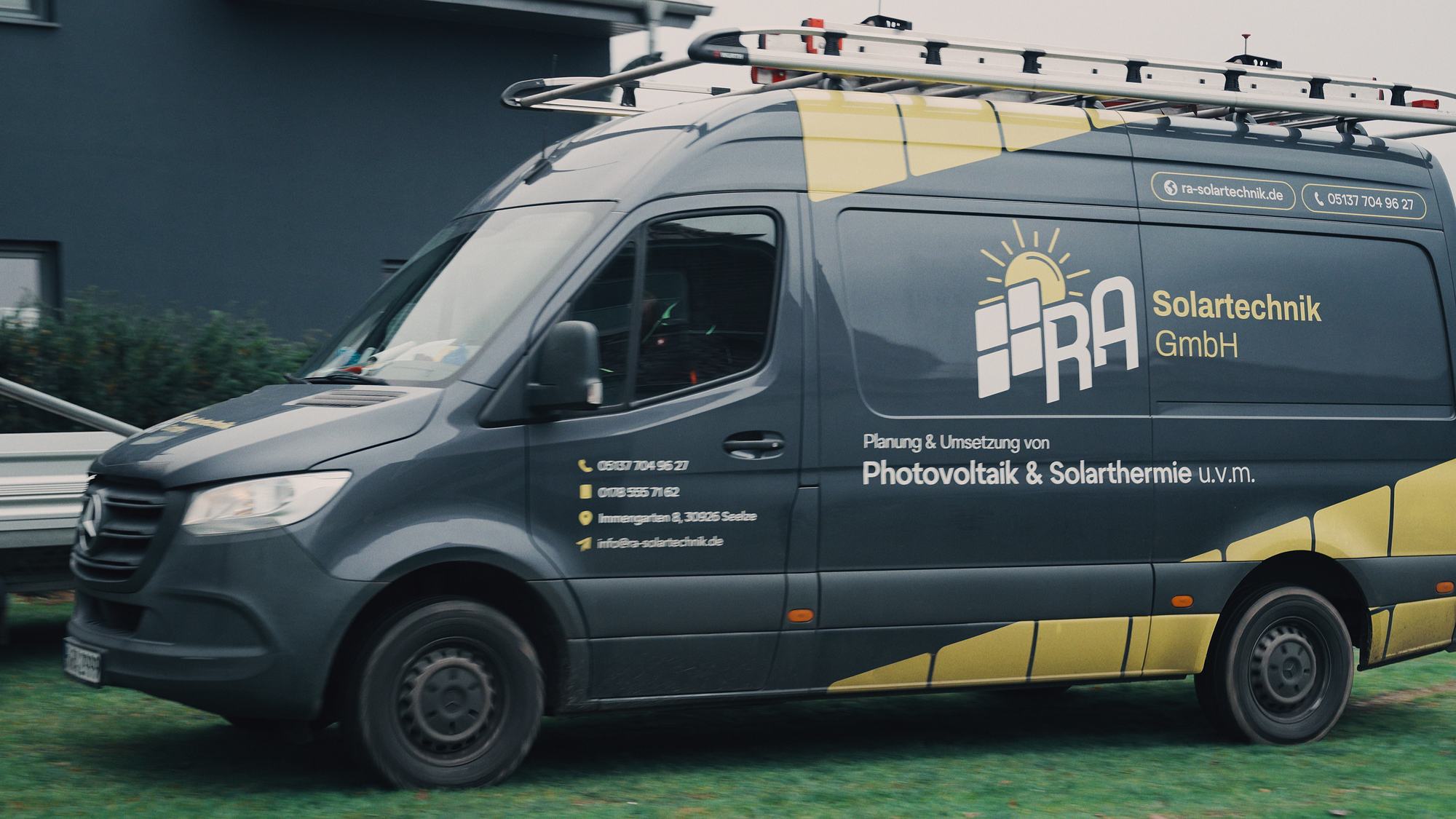 Firmentransporter von RA Solartechnik mit gelber Folierung und Logo