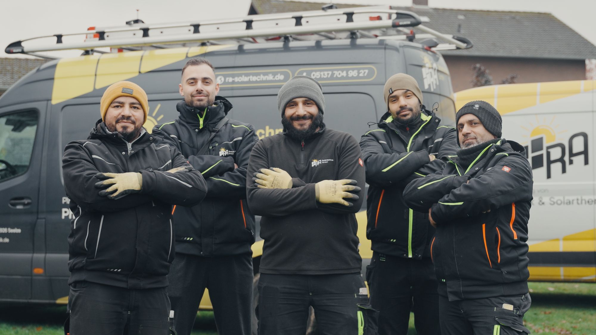Das Team von RA Solartechnik steht mit verschränkten Armen vor dem Firmentransporter